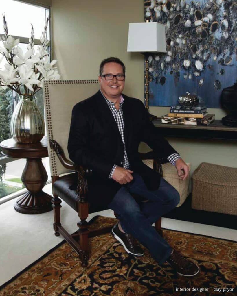 Professional portrait of Clay Pryor seated next to a decorative console table.